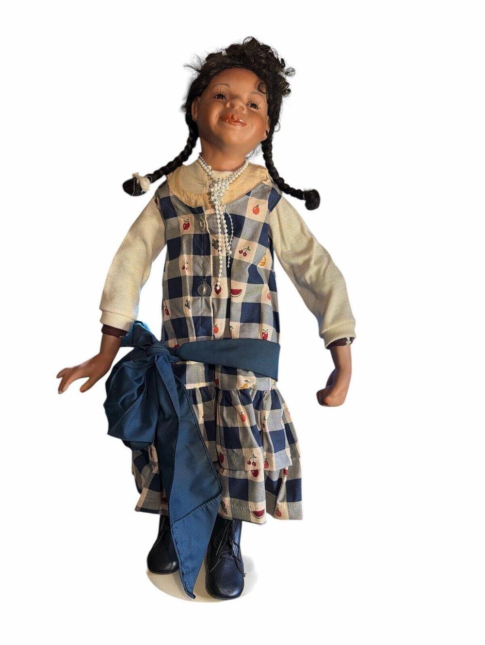 doll porcelain doll featuring a girl with dark pigtails, wearing a checkered dre